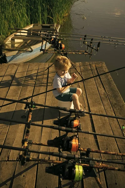 Niño pequeño con caña de pescar cerca del lago —  Fotos de Stock