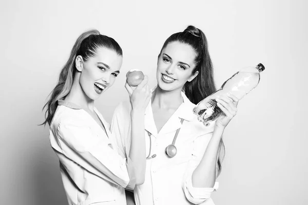 Dwie pielęgniarki dziewczyny szczęśliwy uśmiechający się ze zdrowymi zębami biały uśmiech — Zdjęcie stockowe