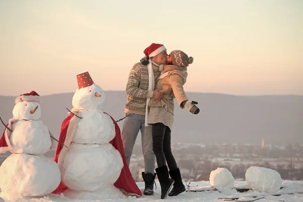 Natale coppia innamorata di uomo e ragazza con pupazzo di neve — Foto Stock