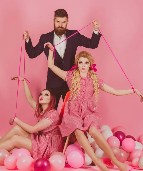 Feestdagen en poppen. dominantie en afhankelijkheid. vintage mode vrouwen pop en man. Creatief idee. Liefde driehoek. Retro meisjes en master in de partij ballonnen. Gek meisjes en man op roze. Halloween — Stockfoto