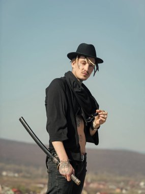 Açık giysili dövmeli gövde siyah şapkalı savaşçı