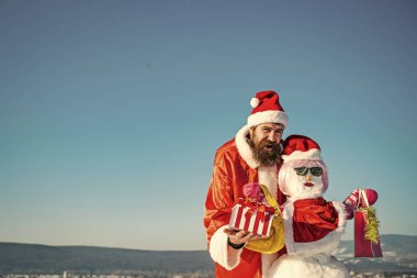 Kardan adam pembe peruk, eldiven ve gözlük ile alışveriş torbaları