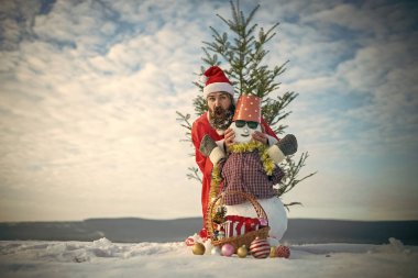 Bulutlu gökyüzü üzerinde karlı heykel ile poz adam