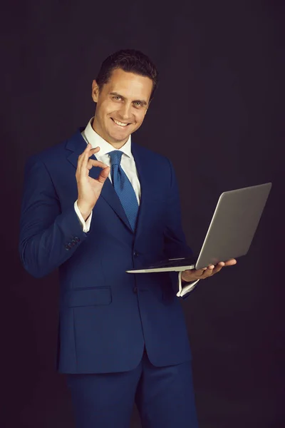 Молодий щасливий бізнесмен з ок жестом і ноутбуком — стокове фото