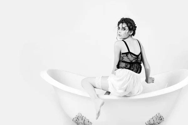 Junge Frau ruht sich in Badewanne mit modischem Haar aus — Stockfoto