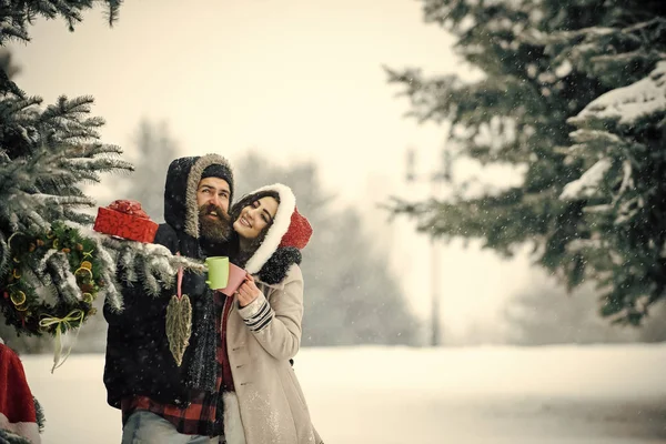 Verliebtes Paar im Winter mit roter Weihnachtsmann-Mütze. — Stockfoto