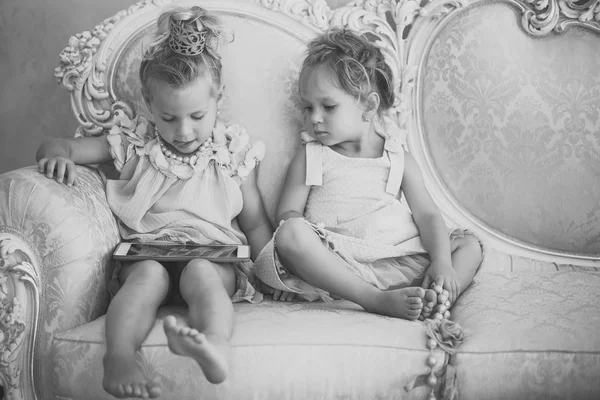 Bebê meninas sentar no sofá clássico — Fotografia de Stock
