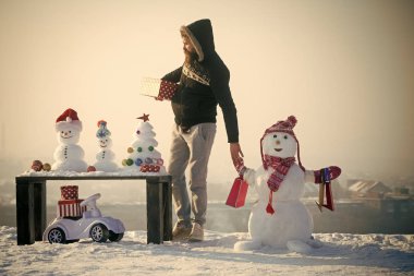 Adam ve kardan adam ile alışveriş torbaları üzerinde beyaz gökyüzü