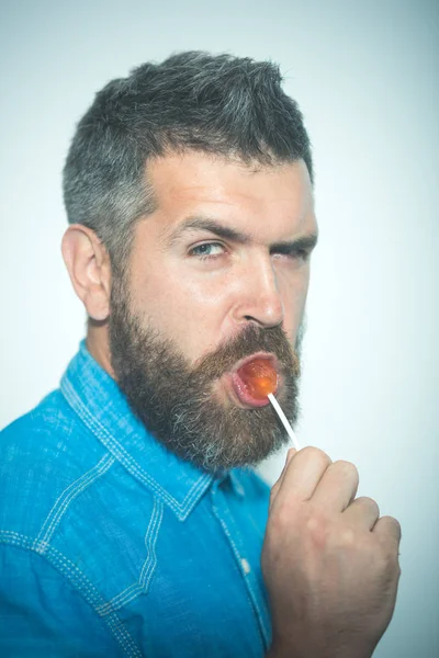 Söta tänder. Man av mode suga godis. Skäggig man. Stilig man med skägg och mustasch. Beard modetrend. Frisör eller barbershop. Min Frisör är bäst. Ett långt skägg är en stil för honom — Stockfoto