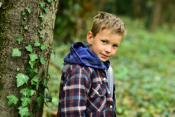 Jede einzelne Kindheit zählt. Ein kleiner Junge genießt seine Kindheit. Kleine Jungen spielen im Wald. Kindheit ist eine kurze Saison — Stockfoto