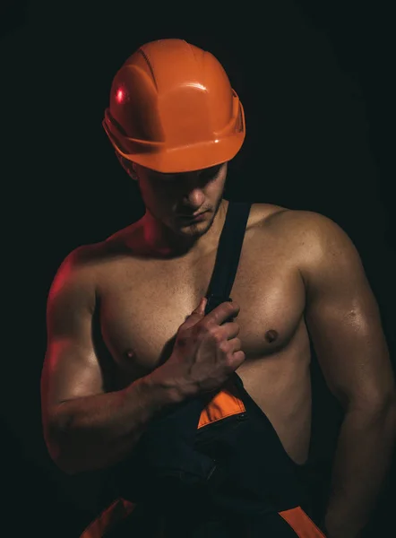 Niet knoeien met de rest, vertrouwen het beste. Bouwvakker of bouwer. Knappe werknemer of workman. Gespierde man dragen hard hat en uniform. De werknemer van de man met gespierde sexy lichaam. Sterk en vol vertrouwen — Stockfoto