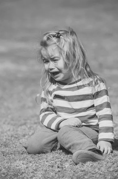 Bebê menino chorar em camisa listrada e jeans azul ao ar livre — Fotografia de Stock