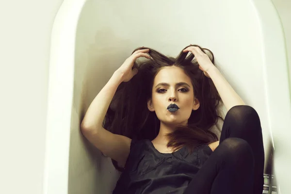 Mujer en vestido con pelo largo, lápiz labial negro en el baño — Foto de Stock