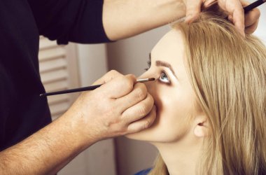 Kız yüz fırça ile göz makyajı uygulayarak Visagiste