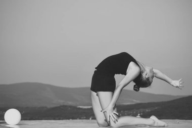 Yeşil topu ile siyah spor giyim kadın jimnastikçi.