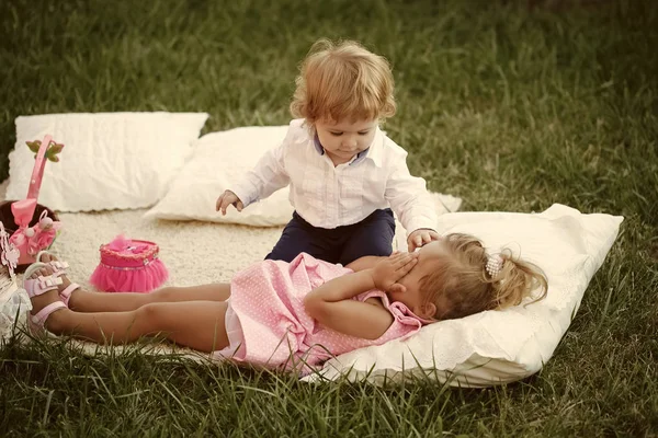 Dzieci, zrelaksować się na zielonej trawie na letni dzień — Zdjęcie stockowe
