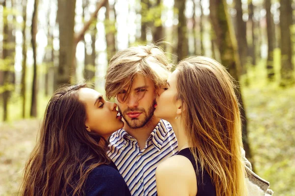 Man getting kiss by two pretty girls — Stock Photo, Image