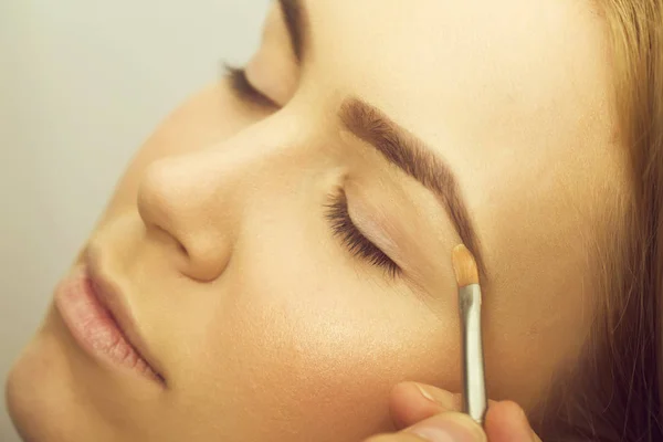 Ragazza con gli occhi chiusi ottenere il trucco sulle palpebre — Foto Stock