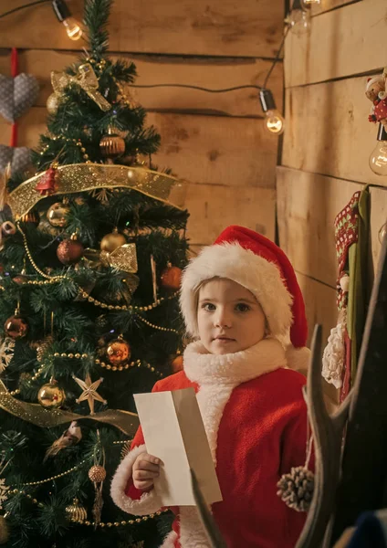 Weihnachtsmann-Kind am Weihnachtsbaum. — Stockfoto