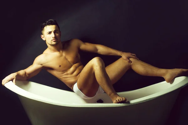 Muskulös man på badkar — Stockfoto