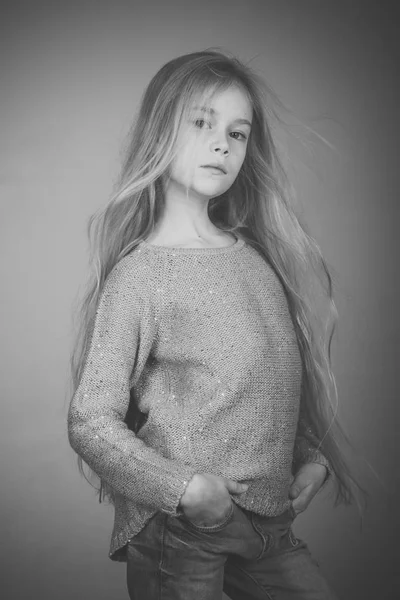 Lyckligt barn lilla flicka poserar på en tom grå vägg — Stockfoto