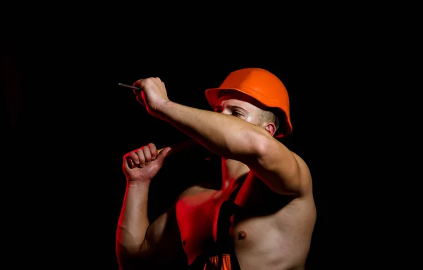 Ahora en construcción. Trabajador duro utilizar la fuerza muscular. Trabajador de la construcción martillar un clavo. El hombre trabaja con martillo. Muscular hombre constructor en el trabajo en construcción — Foto de Stock