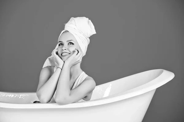 Mujer sexy feliz con turbante toalla sentado en bañera blanca —  Fotos de Stock