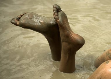 Kirli topuklar ve ayaklar. Bacaklar çamur banyosunda popo. Çamur banyosu kadında. Spa yordam ve vücut bakımı. Çamur keyfi.