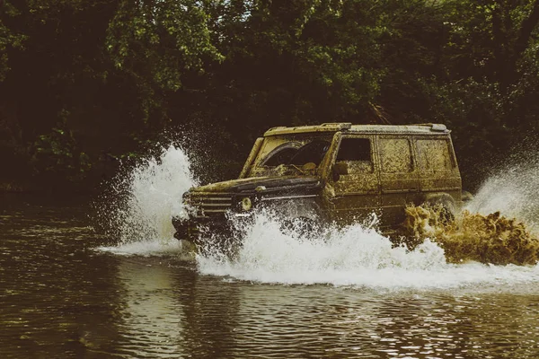 Sefer offroader. Drag racing araba lastik yakar. Mudding off-Road'a benziyor ıslak çamur veya kil bir alan üzerinden. Aşırı. Off-road araç. Yoldan yarış içinde çamur ve su sıçrama. — Stok fotoğraf