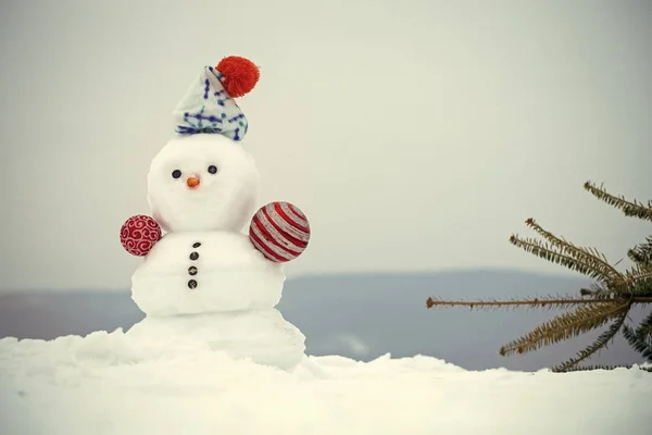 Muñeco de nieve y abeto sobre fondo cubierto de nieve — Foto de Stock