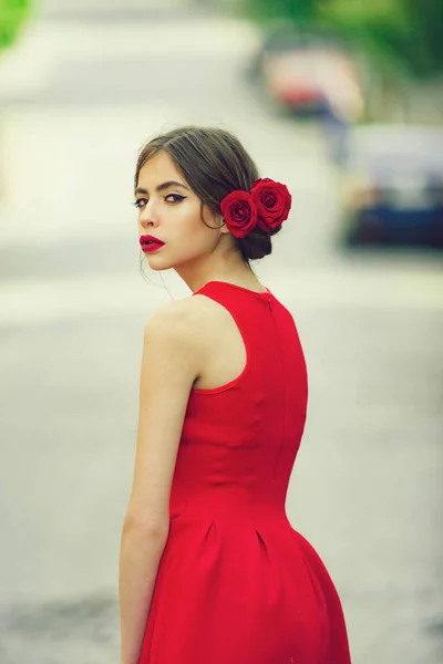Dívka v módní červené šaty chůze po silnici — Stock fotografie