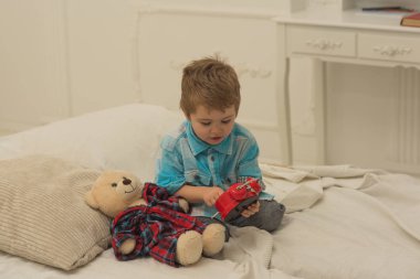 evde küçük çocuk oyun. Çocuk oyun oyuncaklar. Aile ve çocuk günün kutlu olsun. mutlu çocukluk. Bakım ve geliştirme. Ayı ile küçük bir çocuk. Aile gelenekleri. Çok neşeli. Muhteşem gün