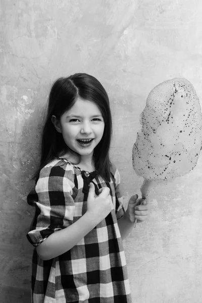 Menina adorável feliz sorrindo com algodão doce no pau — Fotografia de Stock