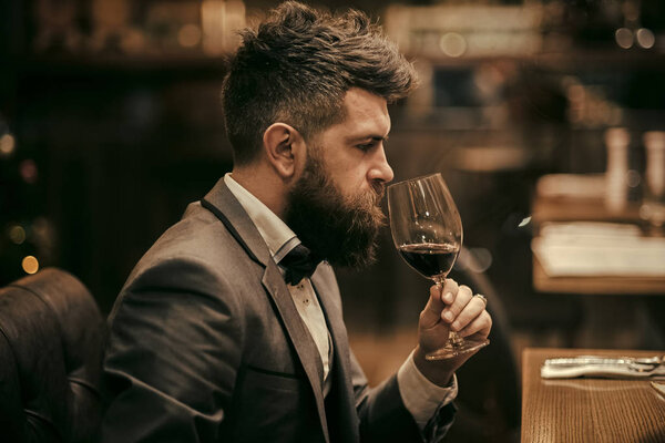 Perfect wine. Businessman with long beard drink in cigar club. bar customer sit in cafe drinking alcohol. Bearded man rest in restaurant with wine glass. Date meeting of hipster awaiting in pub.
