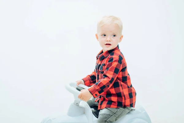Fun but safe. Little baby enjoy playing in kindergarten. Little child ride on toy car. Boy child on riding toy. Small toddler builds balance and motor skills. Child day care or nursery, copy space