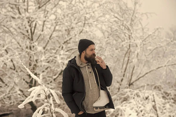 Sakallı adam tutun paten karlı kış orman, Noel, sigara içmek — Stok fotoğraf