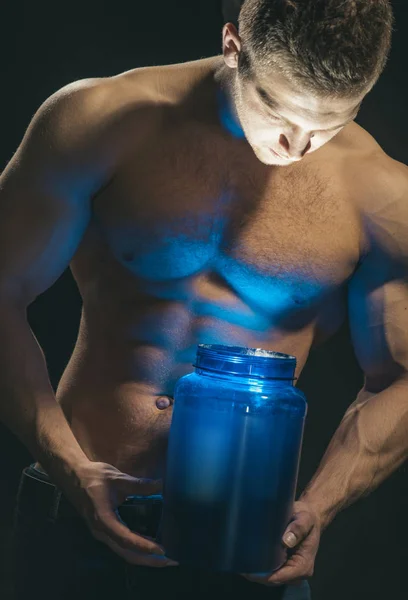 Healthy diet and fitness. Man use sport vitamin supplements for muscle building. Sport nutrition and vitamin diet. Athletic man open vitamin bottle with led light in strong arms. Keeping you strong — Stock Photo, Image