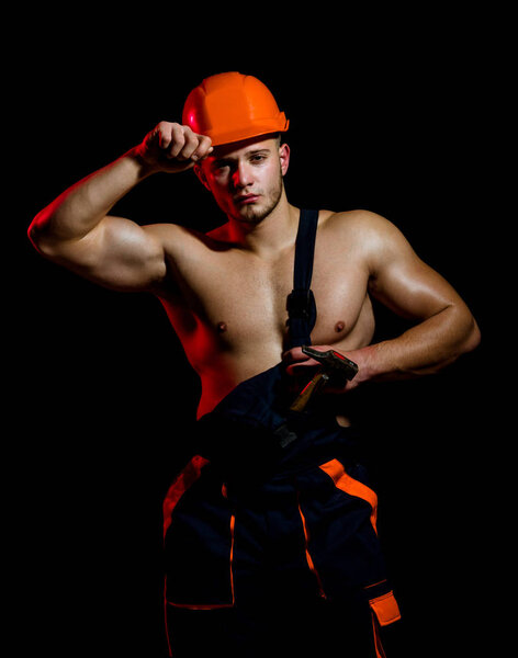 Under construction, it will appear soon. Man work with hammer. Hard worker use muscular strength. Construction worker hammer a nail. Muscular man builder at work under construction