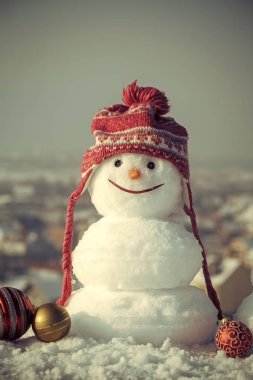 Mavi gökyüzü arka plan üzerinde kırmızı şapkalı kardan adam