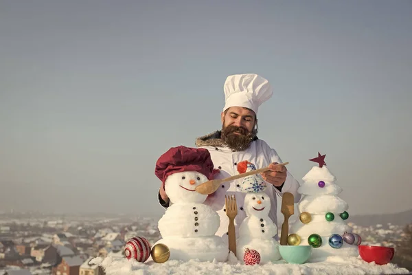 Щасливий чоловік годує сніговиків ложкою — стокове фото