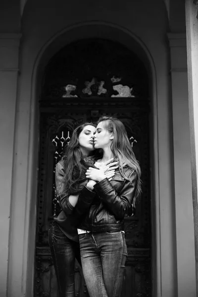 Mooie meisjes zoenen en knuffelen in spijkerbroek op voordeur — Stockfoto