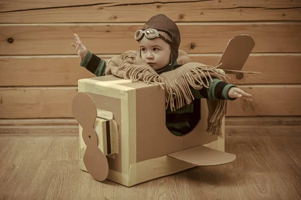 Niño pequeño jugar en avión de cartón, la infancia . — Foto de Stock