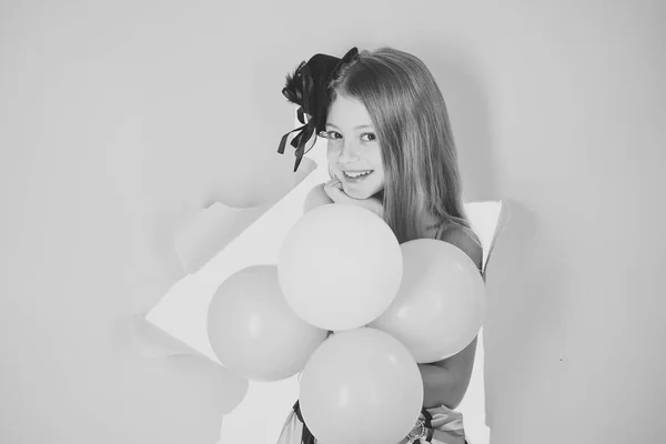 Little girl playing with balloons in pink studio — Stock Photo, Image