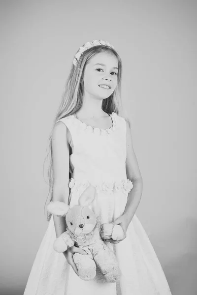 Verbluffende schoonheid jong meisje model in de witte communie jurk staat in studio met konijn speeltje — Stockfoto