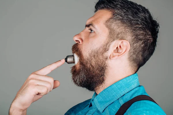 Mannen. hane med skägg. Skäggig brutal man. skäggig man med lampa i munnen. Mogen hipster med skägg. brutala kaukasiska hipster med mustasch. lysa upp tanken. bra idé — Stockfoto