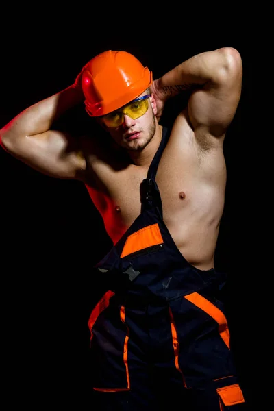 Ma réputation repose sur des bases solides. Travailleur homme avec corps musclé sexy. Beau travailleur ou ouvrier. Ouvrier de la construction ou constructeur. Homme musclé porter un casque dur et uniforme. Confiant et fort — Photo