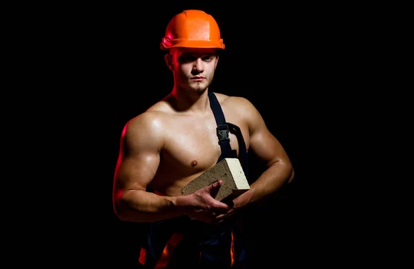 Als het gaat om bouw doen we het allemaal. Man werknemer baksteen in musculaire handen houden. Bouwvakker of de bouwer op het werk op de bouwplaats. Metselaar werknemer. Gespierde man werkt metselwerk — Stockfoto