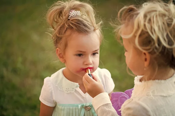 Дитина наносить червону помаду на губи моделі дитини — стокове фото
