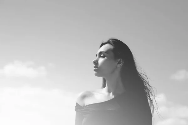 Жінка позує в чорному зверху на блакитному небі — стокове фото