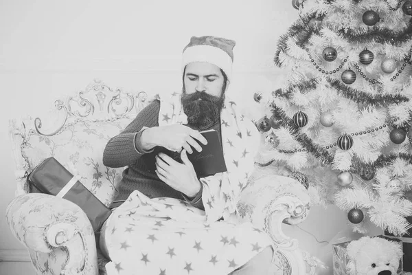 Weihnachtsmann mit Bart und ernstem Gesicht liest Buch. — Stockfoto